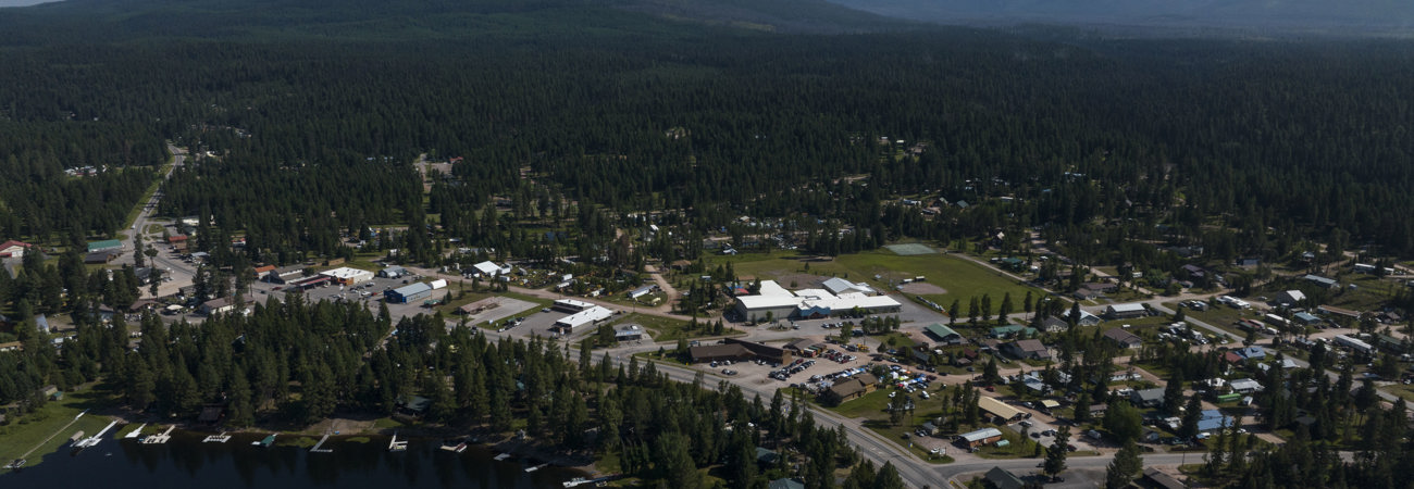 Aerial view of downtown Seeley Lake in summer with mountains in the background