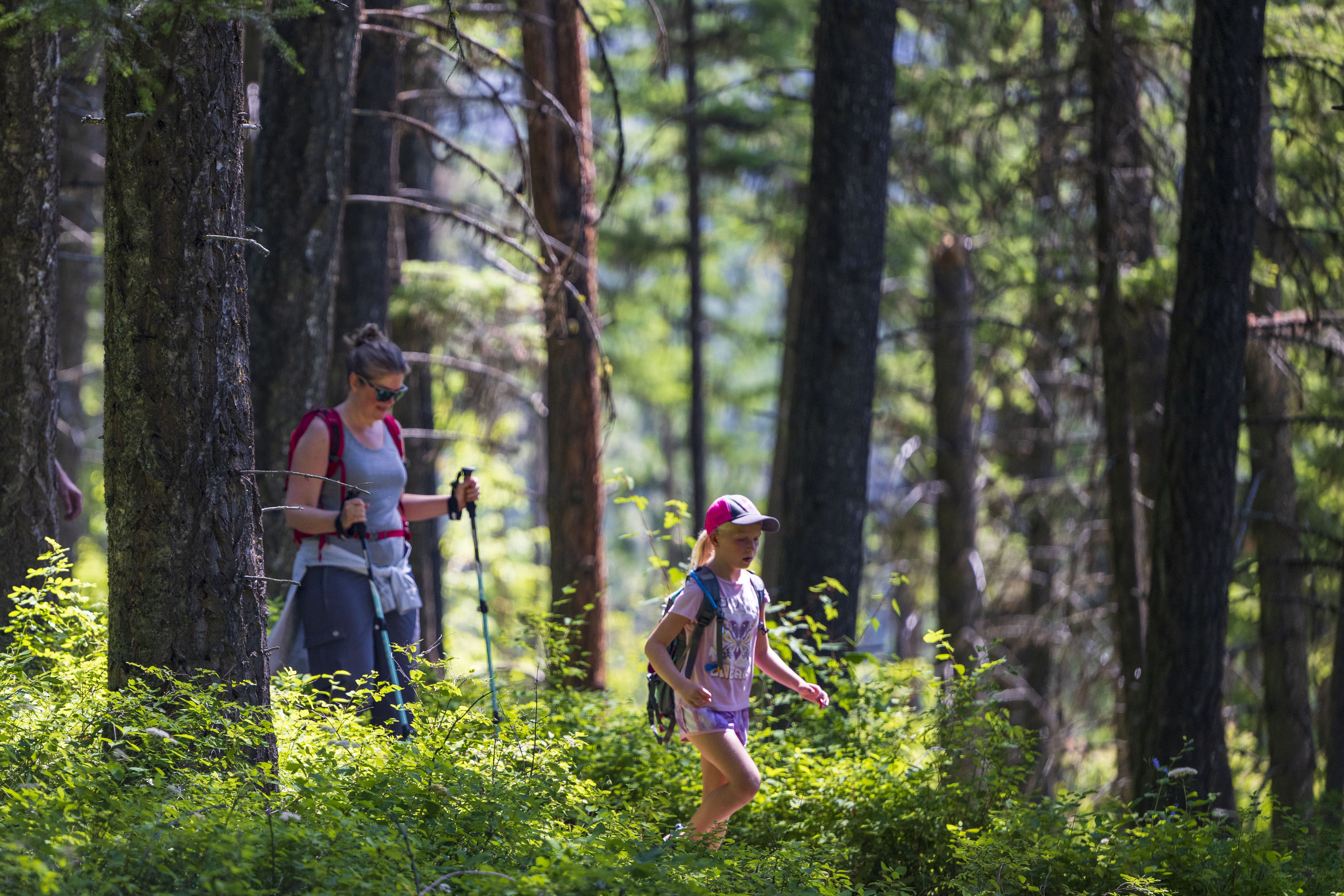 Mother and daughter on a hike at Holland Lake with trees in the background